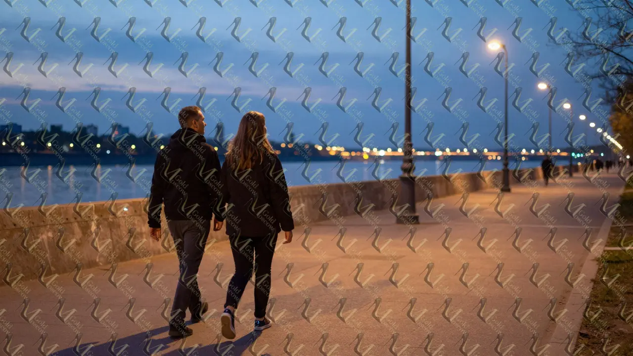 Пар прогуливается по берегу Москвы-реки вечером, атмосфера уюта и доверия.